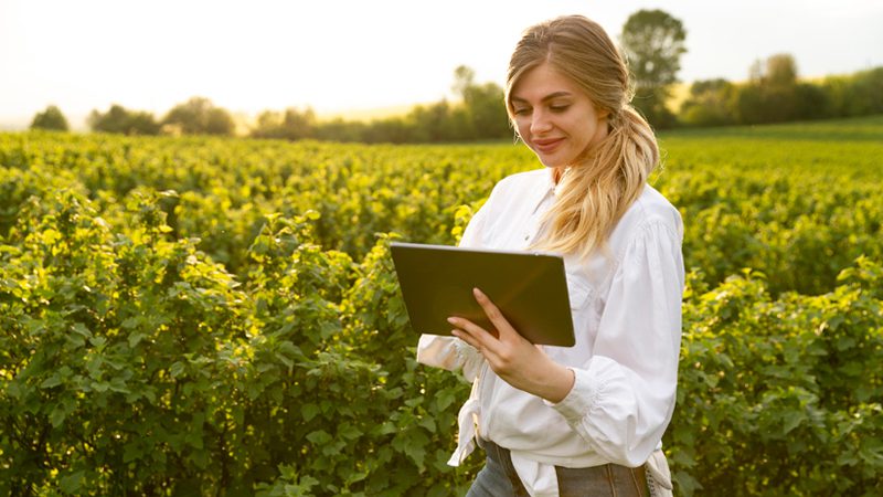 Mulher com tablet no campo